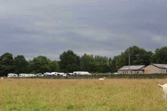 Caravan clubs A view encompassing the village hall with many caravans lined up in the overflow car park field