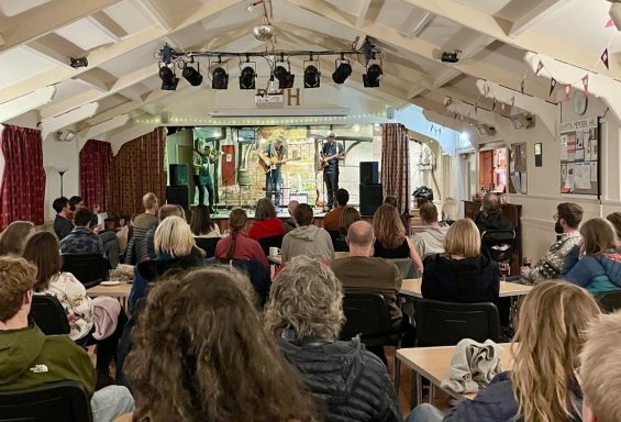 Concerts A acoustic musician and his band mates play to an audience