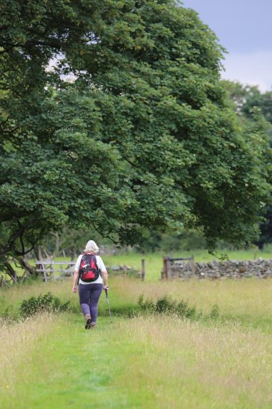 Walking & Camping Groups Lady walks along the riverside path