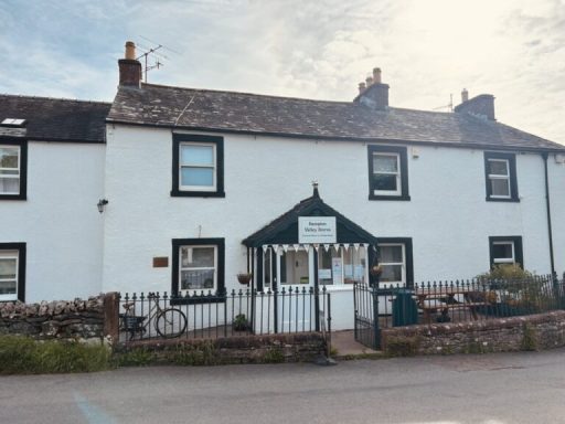 Village Stores An image of the facade of the Village Stores in Bampton showing the traditional iron railings, a bicycle and a picnic table
