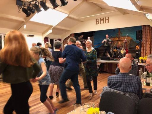 Ceilidhs All ages dancing together in front of a Ceilidh band performing on the stage